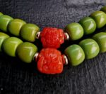 turquoise mala adorned with coral and gold beads close view