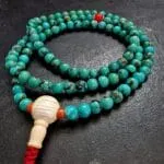 Close-up of genuine natural turquoise mala beads showing unique stone matrix patterns and