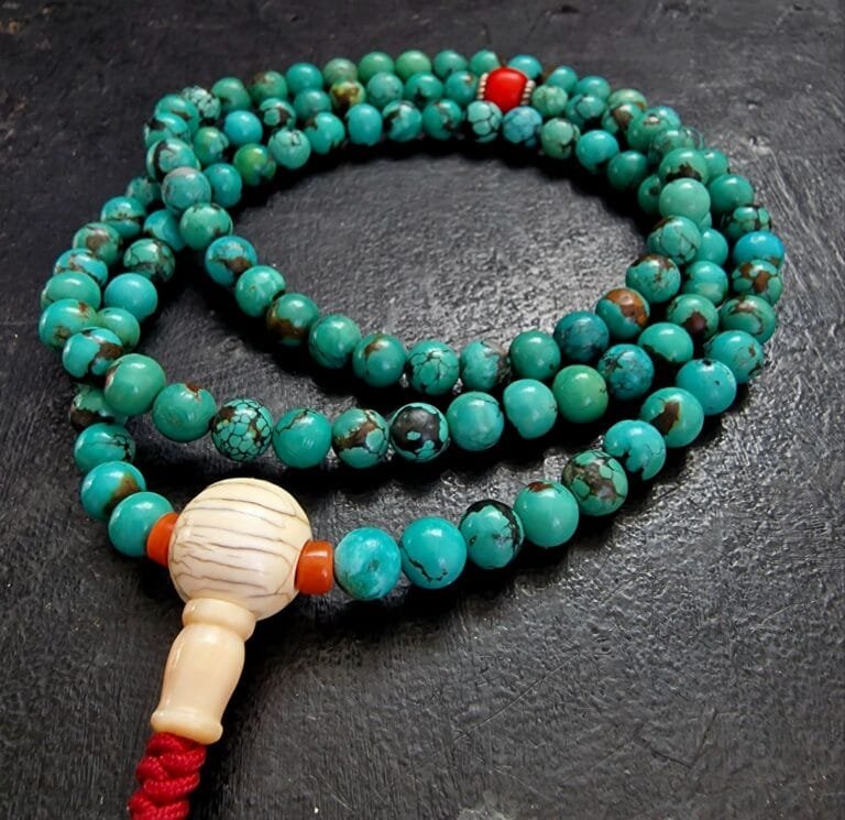 Close-up of genuine natural turquoise mala beads showing unique stone matrix patterns and