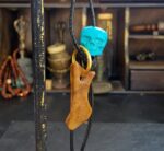 Hand-carved Kapala amulet inlaid with natural turquoise.