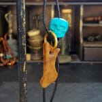 Hand-carved Kapala amulet inlaid with natural turquoise.