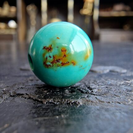 Hand-carved Tibetan turquoise bead with a natural dark matrix.