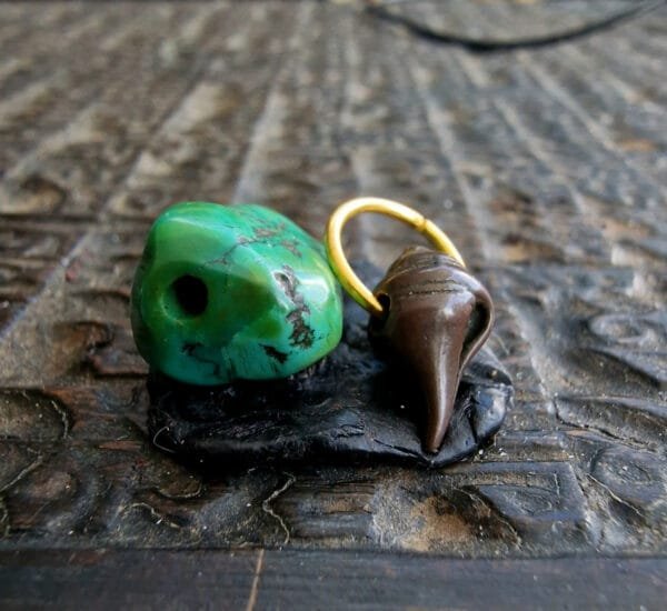 Ancient turquoise bead with copper alloy thogchag