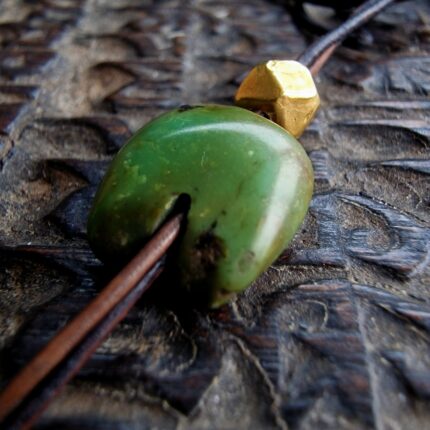 Hand-carved Tibetan turquoise bead with a natural black matrix pattern.