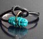 Hand-carved turquoise Vajra with a natural dark matrix.