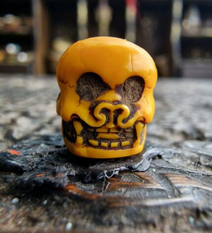 Hand-carved Chittipati bone bead with a detailed dancing skeleton motif.