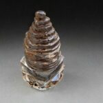 Hand-carved clear crystal temple stupa with precise ritual geometry.