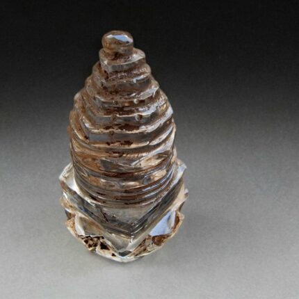 Hand-carved clear crystal temple stupa with precise ritual geometry.