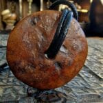Hand-carved Kapala skull bone amulet on a ritual cord necklace.