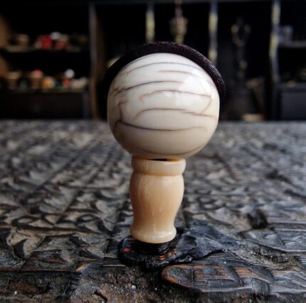 Hand-carved ivory-tone bone guru bead with a smooth ritual patina.