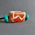 Hand-etched antique Chong Dzi bead with traditional linear patterns.