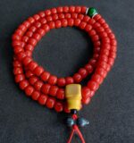 Hand-polished Sherpa coral prayer beads with authentic ritual wear.