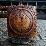 Hand-carved bone Kapala amulet featuring a detailed memento mori skull.