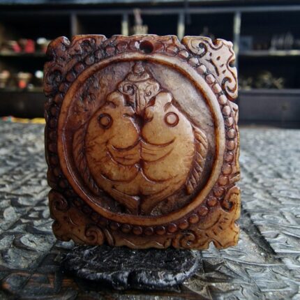 Hand-carved bone Kapala amulet featuring a detailed memento mori skull.