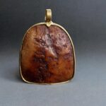 Hand-carved antique bone Kapala amulet featuring a detailed ritual skull with a deep waxy patina.