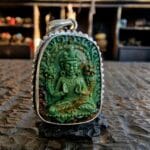 Hand-carved Tibetan Turquoise Avalokiteshvara figure showing intricate ritual details and natural matrix.
