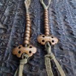 Hand-cast Tibetan mala counters featuring traditional Vajra and Bell symbols.
