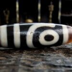 Hand-etched 2-eye Dzi bead featuring traditional sacred geometry.