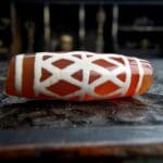 Hand-etched Dzi bead featuring sacred Vajra eye symbols and ritual patina.