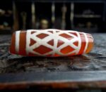 Hand-etched Dzi bead featuring sacred Vajra eye symbols and ritual patina.