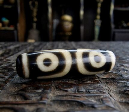 Authentic Tibetan 3-Eye Dzi bead featuring clear circular motifs on high-quality etched agate.