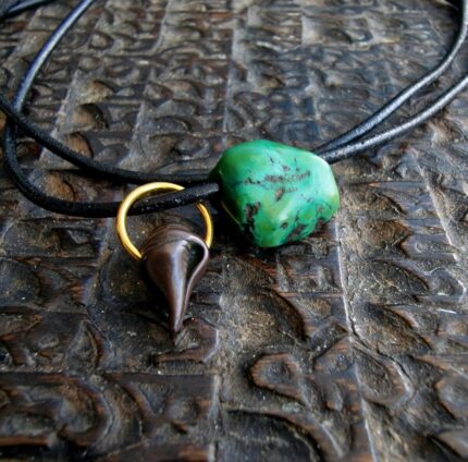 Hand-carved turquoise amulet featuring a natural blue-green matrix and ritual patina.