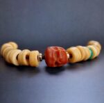 Hand-polished ivory-toned bracelet beads featuring a smooth ritual patina.