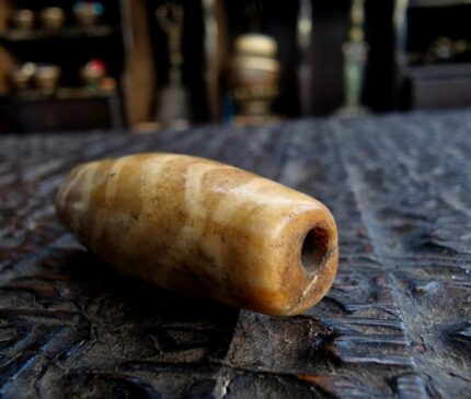 Authentic Himalayan Pumtek bead featuring hand-etched geometric patterns on fossilized wood.