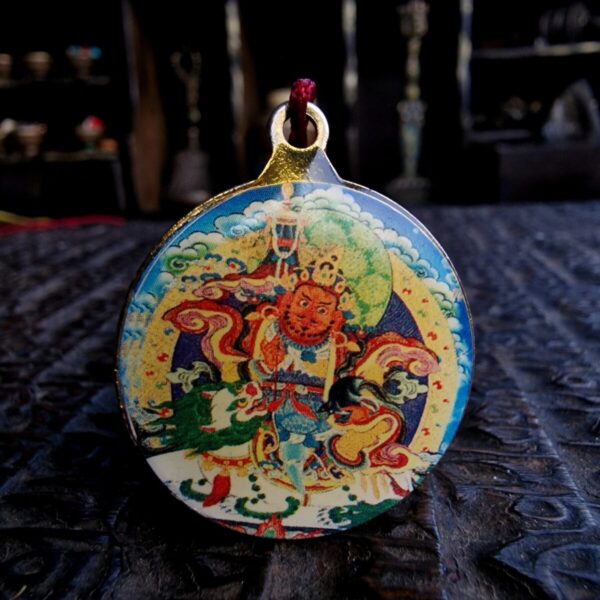 Hand-cast Tibetan Jambala amulet depicting the God of Wealth in a traditional ritual pose.
