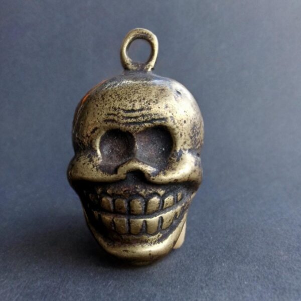 Antique Tibetan Chittipati skull amulet featuring a hand-carved skeletal face with a rich ritual patina.