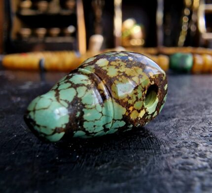 Hand-carved turquoise Guru bead set with a natural blue-green matrix and ritual hole.
