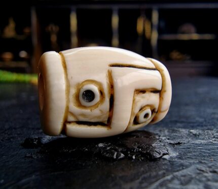 Hand-etched Dzi bead with ivory-toned patina featuring traditional sacred geometry.