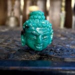 Himalayan moss turquoise Buddha bead hand-carved with natural green and ochre mineral inclusions.