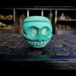 Tibetan Turquoise Chitipati bead hand-carved skull with grinning teeth and natural turquoise veins.
