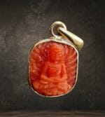 Himalayan coral Shakyamuni pendant hand-carved orange-red seated Buddha in gold bezel.